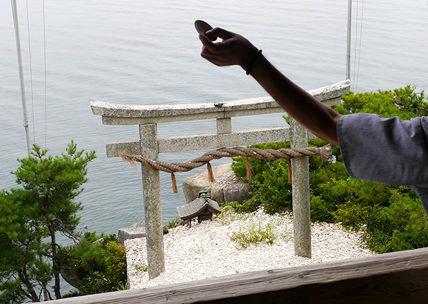 かわらけ投げ 鳥居をめがけて投げる