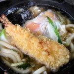 大きなエビの天ぷらがのっている鍋焼きうどん