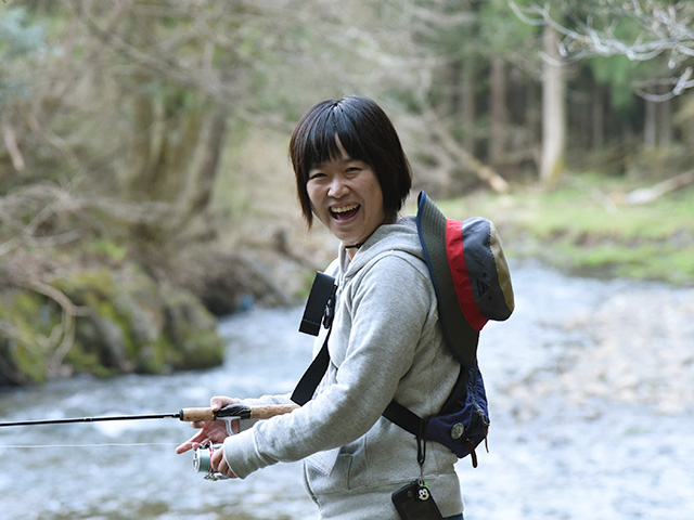 笑顔で渓流釣りをする人